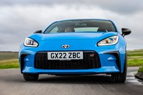Toyota GR86 review: front three quarter tracking cornering, low angle, country road, blue paint