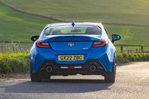 Toyota GR86 review: rear three quarter cornering, low angle, country road, blue paint