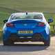 Toyota GR86 review: rear three quarter cornering, low angle, country road, blue paint