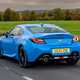 Toyota GR86 review: rear three quarter tracking driving, high angle, country road, blue paint