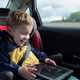 Child in car seat with tablet