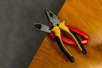 Two pliers on a wooden surface