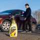 The bottle of Turtle Wax Waterless next to a car being cleaned