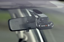 A conventional dash cam installed in a car.