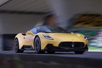 Maserati MC20 (2025) review: front three quarter driving, yellow paint, low angle, graffiti
