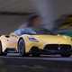 Maserati MC20 (2025) review: front three quarter driving, yellow paint, low angle, graffiti