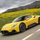 Maserati MC20 (2025) review: side view driving, yellow paint, low angle, graffiti