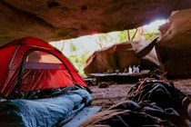 Tent and a sleeping bag in a cave