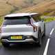 Kia EV9 review (2024): rear three quarter cornering, silver paint, British country road