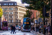 A Manchester street with buses, cars and pedestrians