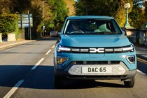 Dacia Spring review - dead-on front, blue, driving in the UK