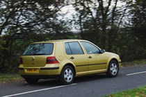 Volkswagen Golf Mk4 review: rear three quarter driving, gold paint, wood in background