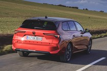 Vauxhall Astra Sports Tourer Electric (2023) review: rear three quarter driving, British country lane, red paint