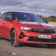 Vauxhall Astra Sports Tourer Electric (2023) review: front three quarter driving, British country lane, red paint