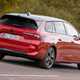 Vauxhall Astra Sports Tourer Electric (2023) review: rear three quarter driving, close-up, British country lane, red paint