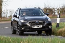 Subaru Crosstrek review (2024): front three quarter cornering, wide shot, grey paint, British country road