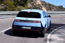 Hyundai Ioniq 5 N (2024) review: rear three quarter driving, mountain pass, matte blue paint, Spanish roads