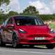 Tesla Model Y: safest cars in the UK 2023, front three quarter cornering, red paint