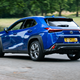 Lexus UX300h (2024) rear three quarters driving