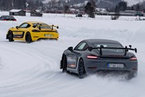The future of fuel: Porsche Cayman prototypes running on eFuel, drifting around a corner on an ice racing circuit, grey and yellow paint