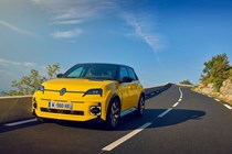 Renault 5 E-Tech (2024) review: front three quarter driving, offset angle, yellow paint, sunny