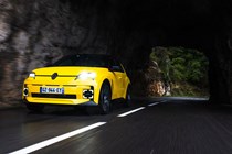 Renault 5 E-Tech (2024) review: front three quarter driving, low angle, yellow paint, through cave