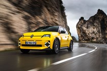 Renault 5 E-Tech (2024) review: front three quarter driving, low angle, yellow paint, through valley