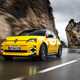 Renault 5 E-Tech (2024) review: front three quarter driving, low angle, yellow paint, through valley