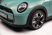 MINI Cooper (2024): headlamp and alloy wheel detail, teal paint, studio shoot