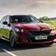 BMW i5 Touring (2024) review: front three quarter driving, red paint