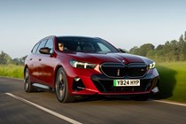 BMW i5 Touring: M60 model, front three quarter driving, sunset, red paint