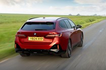 BMW i5 Touring: M60 model, rear three quarter driving, red paint