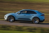 Porsche Macan Electric (2024) review: side view driving, blue paint, fields in background