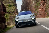 Porsche Macan (2024) review: front driving, mountain road, valley in the background, silver paint