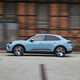 Porsche Macan Electric (2024) review: side view driving, blue paint, past buildings