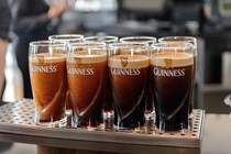 Pints of Guinness lined up on a bar - Driving in Ireland
