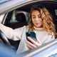 Young sitting in car holding phone - How to report dangerous driving