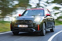 MINI Countryman JCW (2024) review: front three quarter driving, black and red paint