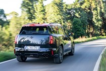 MINI Countryman JCW (2024) review: rear three quarter driving, black and red paint