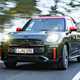 MINI Countryman JCW (2024) review: front three quarter driving, black and red paint