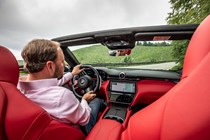 Maserati GranCabrio Trofeo review: interior driving shot, Piers Ward at the wheel, red leather upholstery