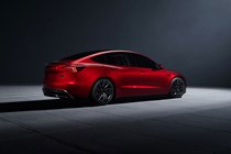 Tesla Model 3 Performance: rear three quarter static, high angle, red paint, studio shoot
