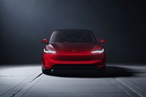 Tesla Model 3 Performance: front static, low angle, red paint, studio shoot