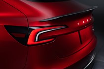 Tesla Model 3 Performance: rear spoiler detail shot, red paint, studio shoot