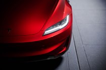 Tesla Model 3 Performance: LED headlight detail shot, red paint, studio shoot