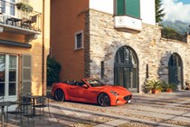 Maserati GranCabrio Folgore review: front three quarter driving through city, orange paint