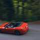 Maserati GranCabrio Folgore review: rear three quarter driving through forest, orange paint