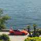 Maserati GranCabrio Folgore review: side view driving along lakeside, orange paint