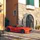 Maserati GranCabrio Folgore review: front three quarter driving through city, orange paint