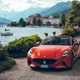 Maserati GranCabrio Folgore review: front three quarter static, lake in background, orange paint